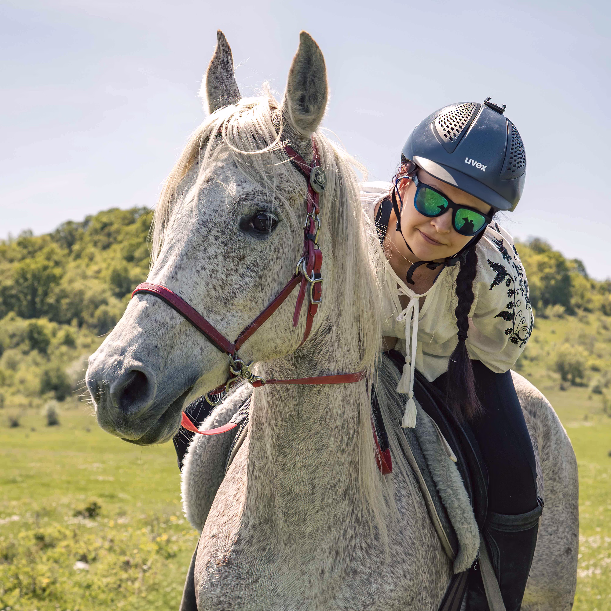 Beau portrait d’un cavalier et de son cheval, avec le reflet net de leurs silhouettes dans les lunettes du cavalier.