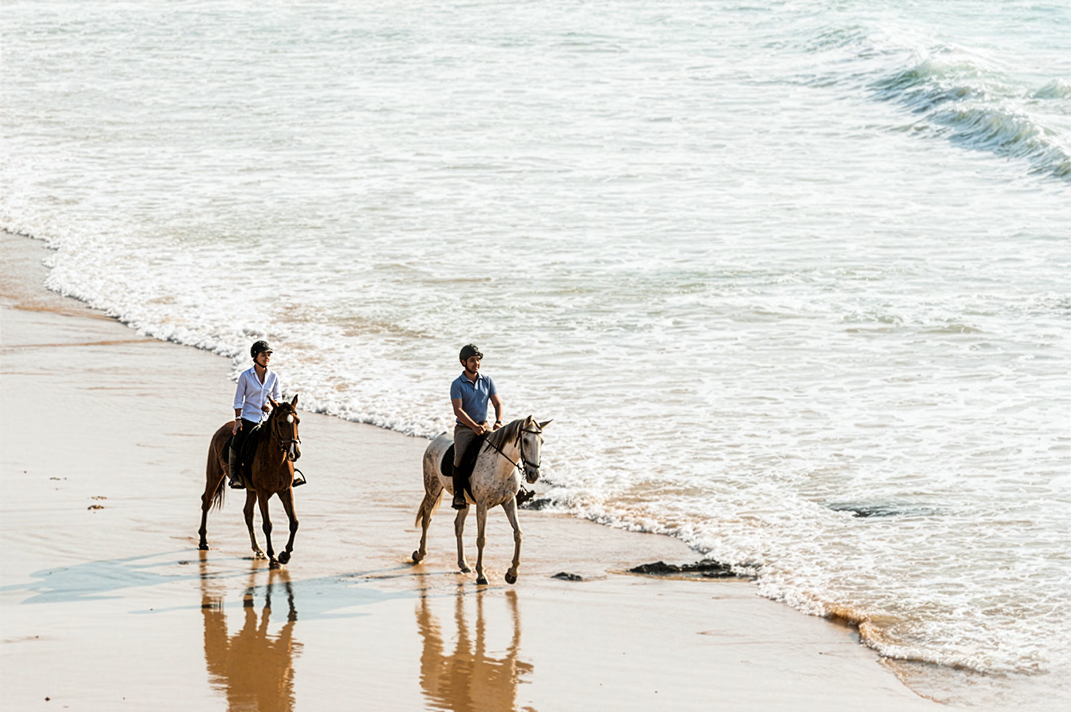 Deux cavaliers sur les rives d'un plage au Portugale