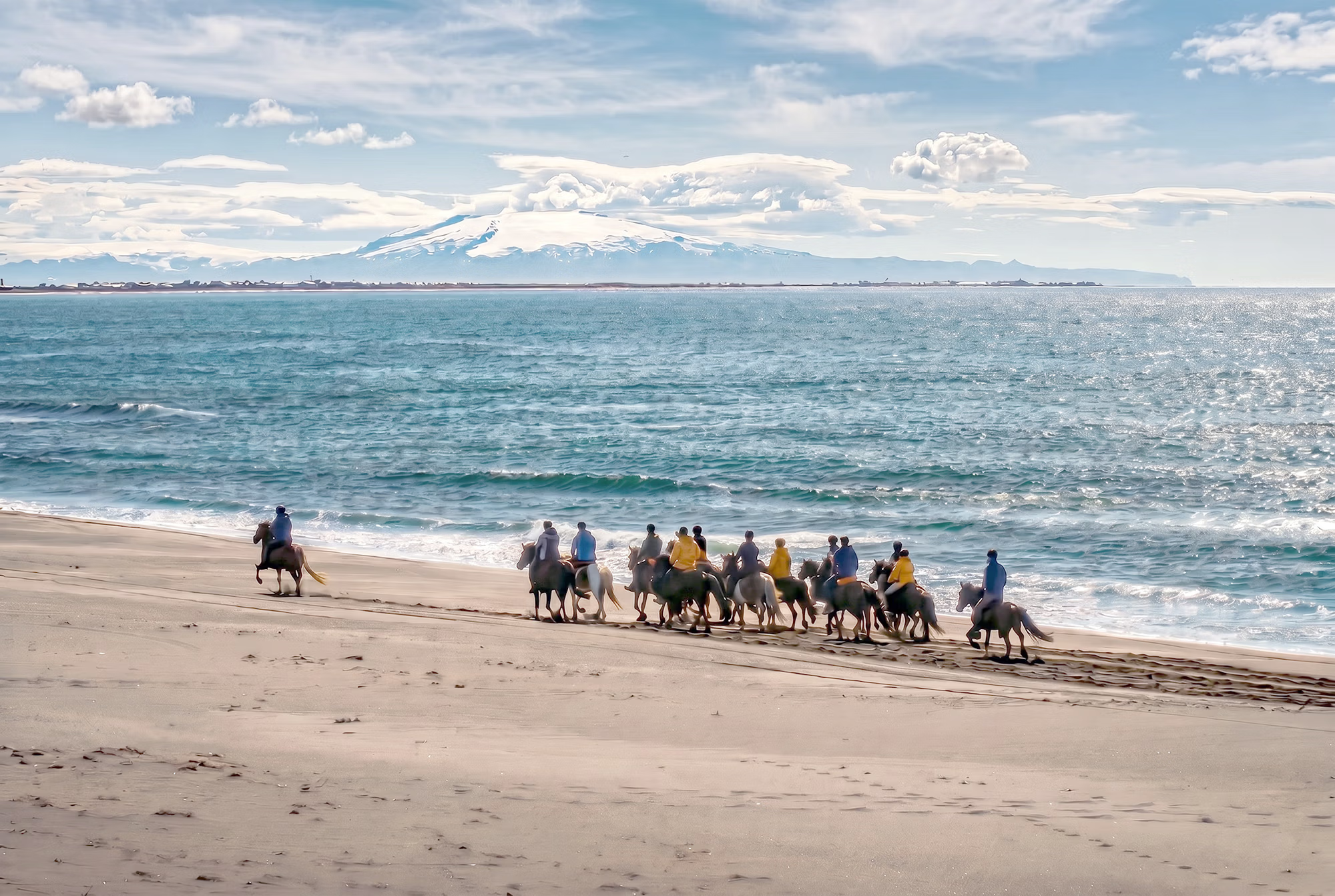 Un groupe de cavaliers au galop sur une plage en Islande
