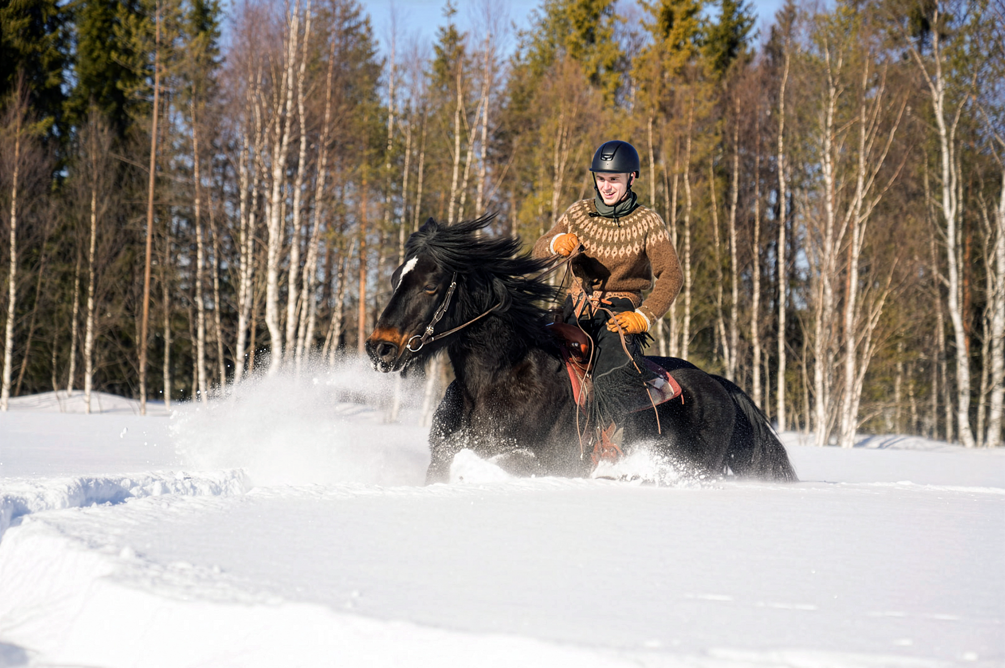 Cavalier au galop dans la neige en Laponie finlandaise