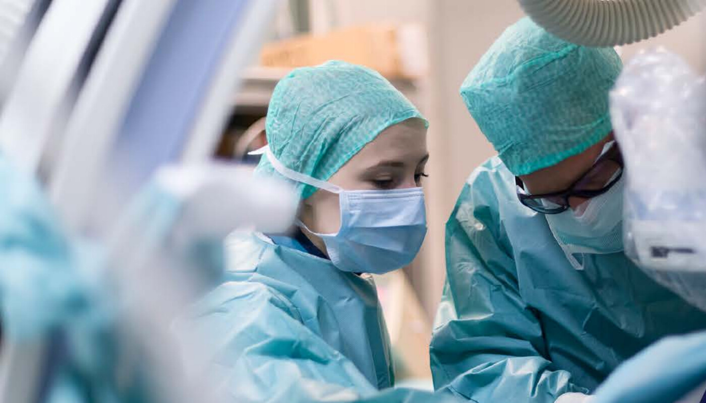 Physicians performing a minimally invasive procedure in the operating room.