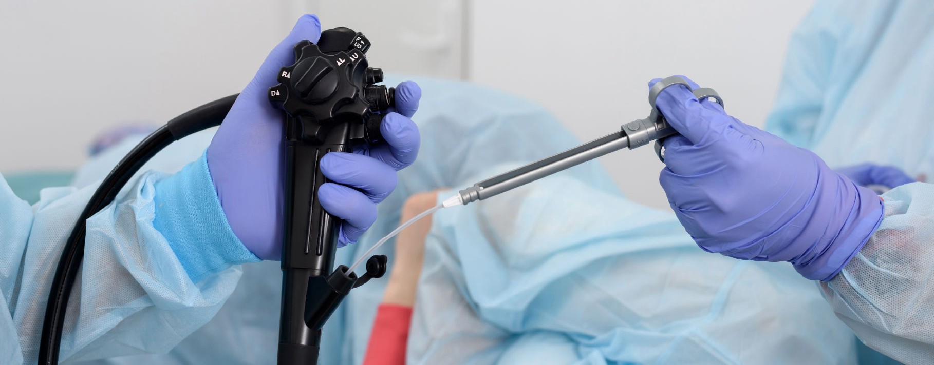 Cardiac catheterization lab team performing a coronary angioplasty, with live fluoroscopic images of the heart displayed on a large monitor overhead.