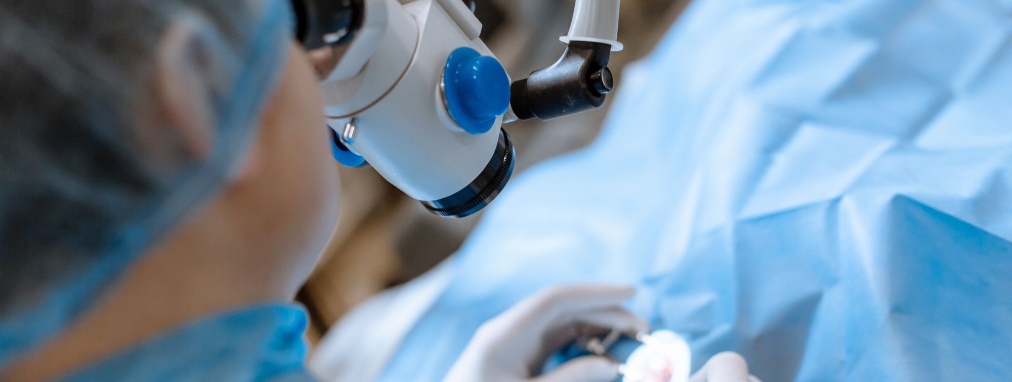 Cardiac catheterization lab team performing a coronary angioplasty, with live fluoroscopic images of the heart displayed on a large monitor overhead.