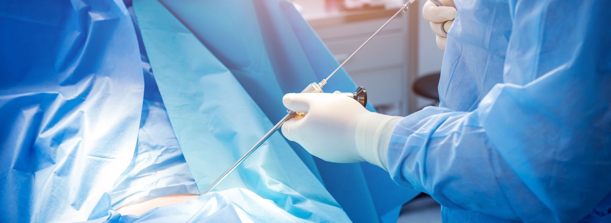 Cardiac catheterization lab team performing a coronary angioplasty, with live fluoroscopic images of the heart displayed on a large monitor overhead.