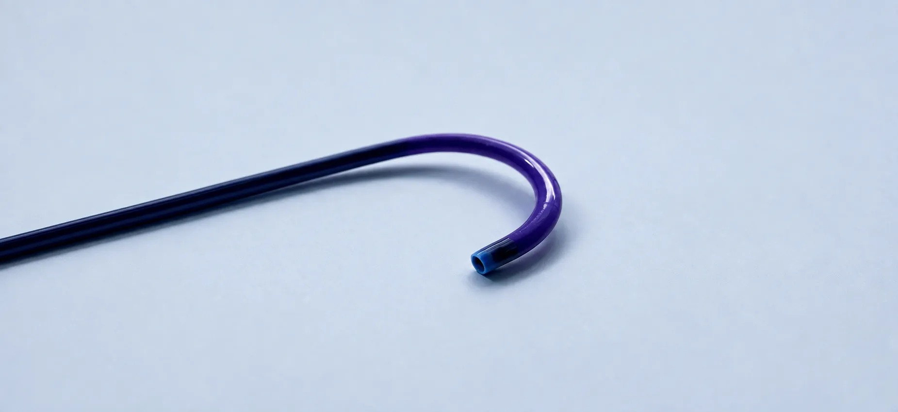 Steerable catheter with a curved J-shaped distal tip in dark blue polymer