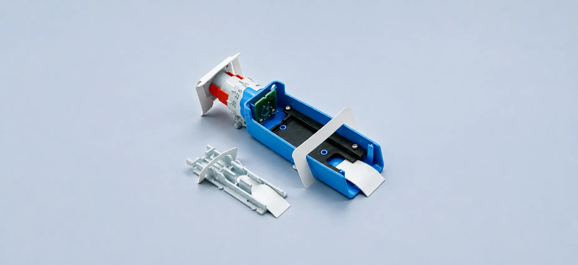Engineering prototype of a medical device assembly with a blue frame and syringe components