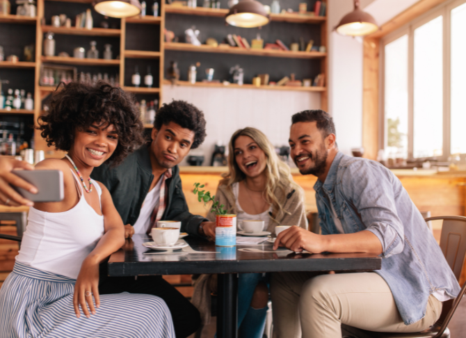 People eating at table taking selfie stock image