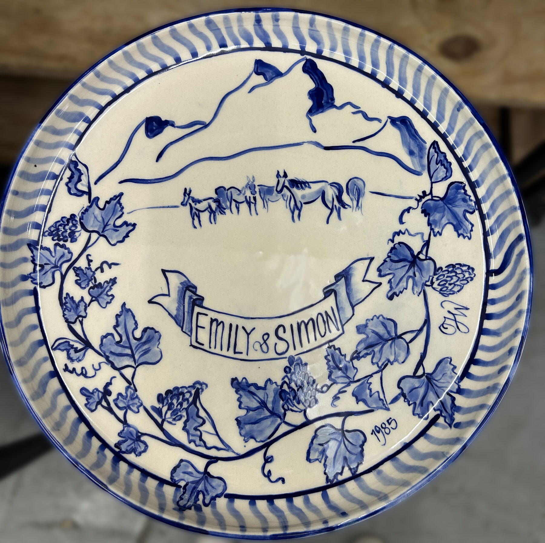 Hand-painted blue and white plate with Patagonian landscape and horses