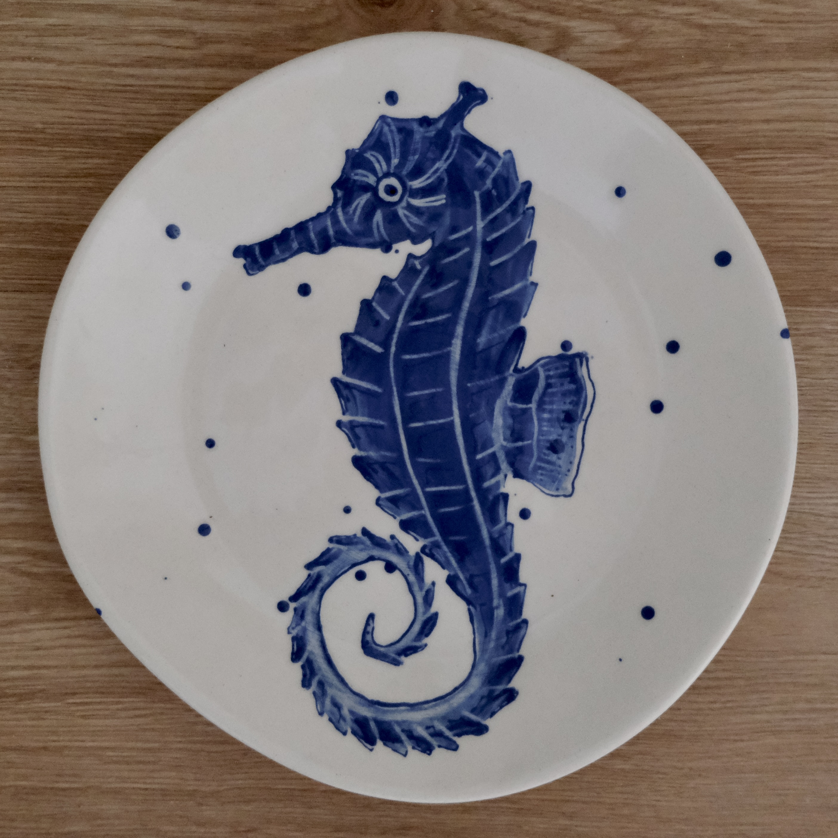 Hand-painted dinner plate with a blue seahorse