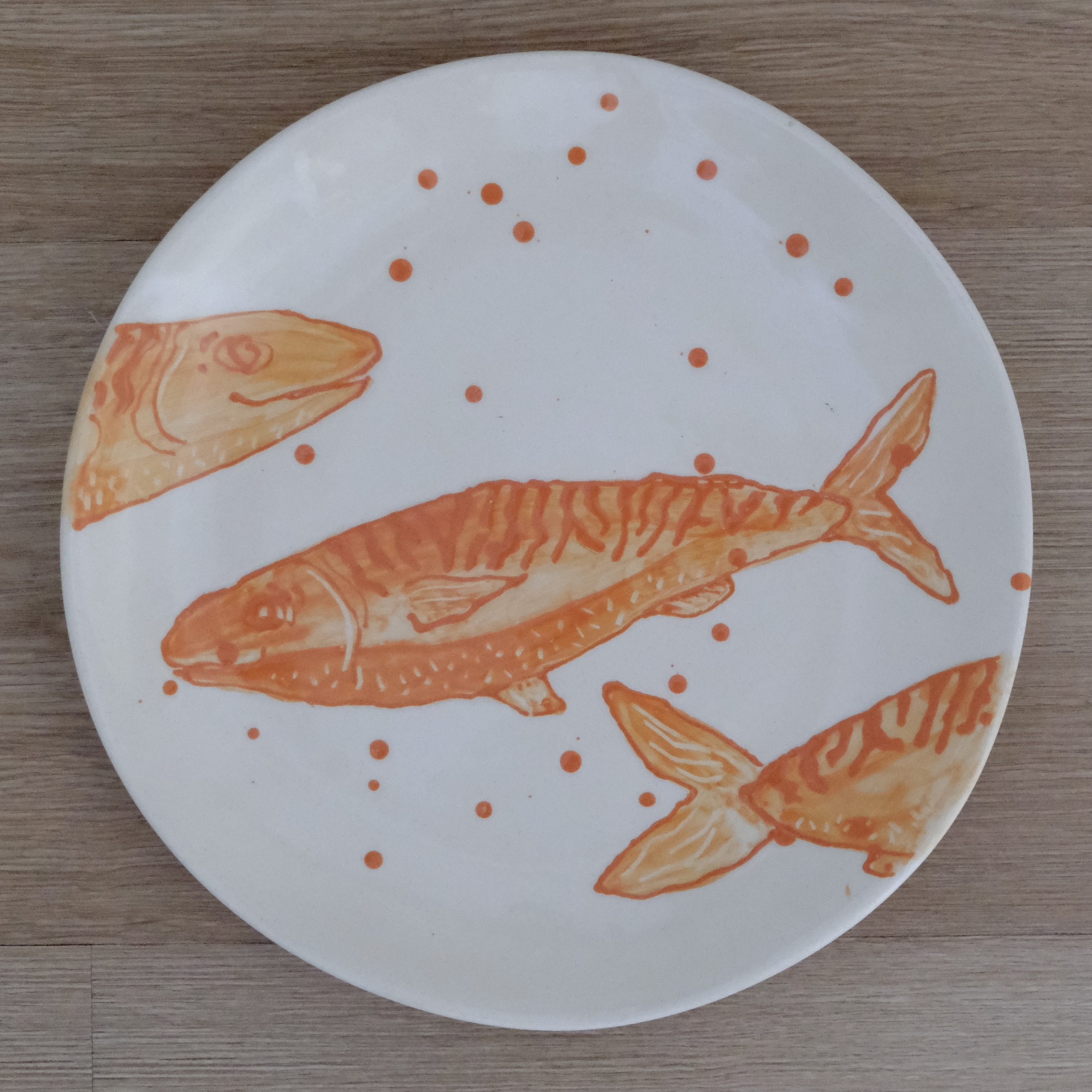 Hand-painted dinner plate with an orange mackerel