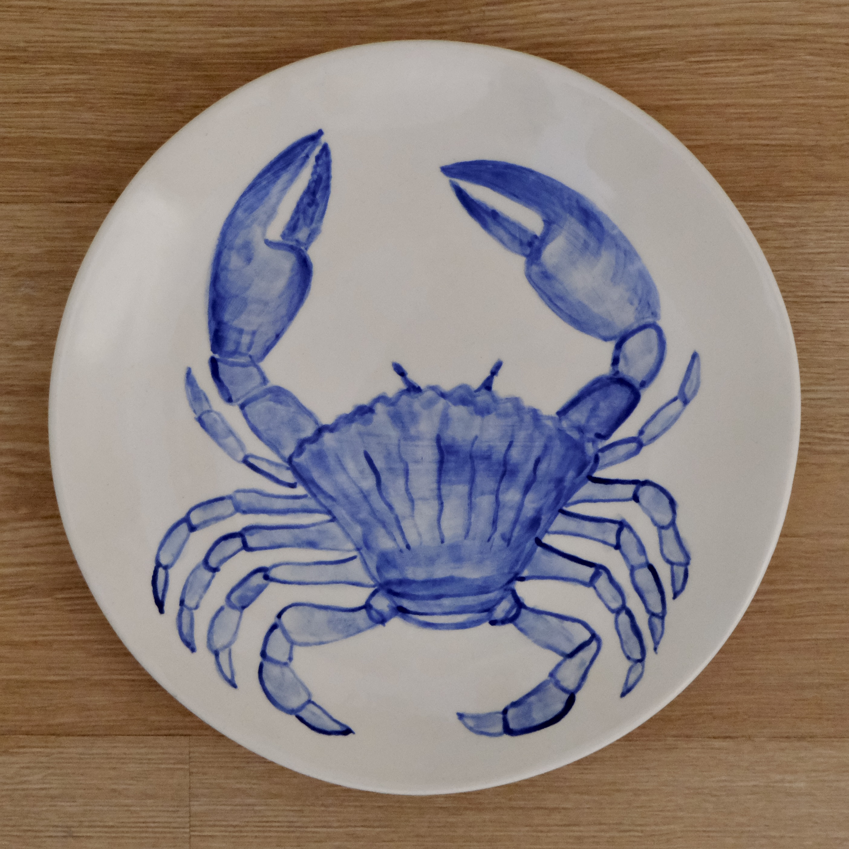 Hand-painted dinner plate with a blue crab