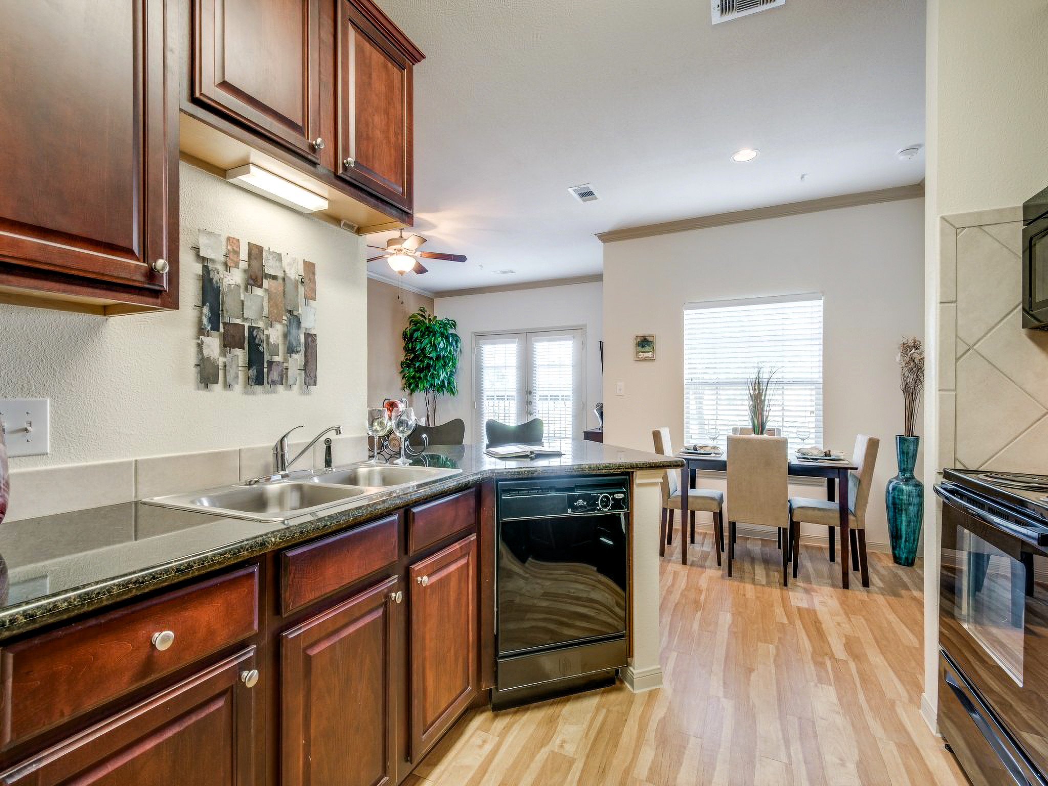 Kitchen with brown cabinets at Lookout Hollow Apartments in Selma, Texas