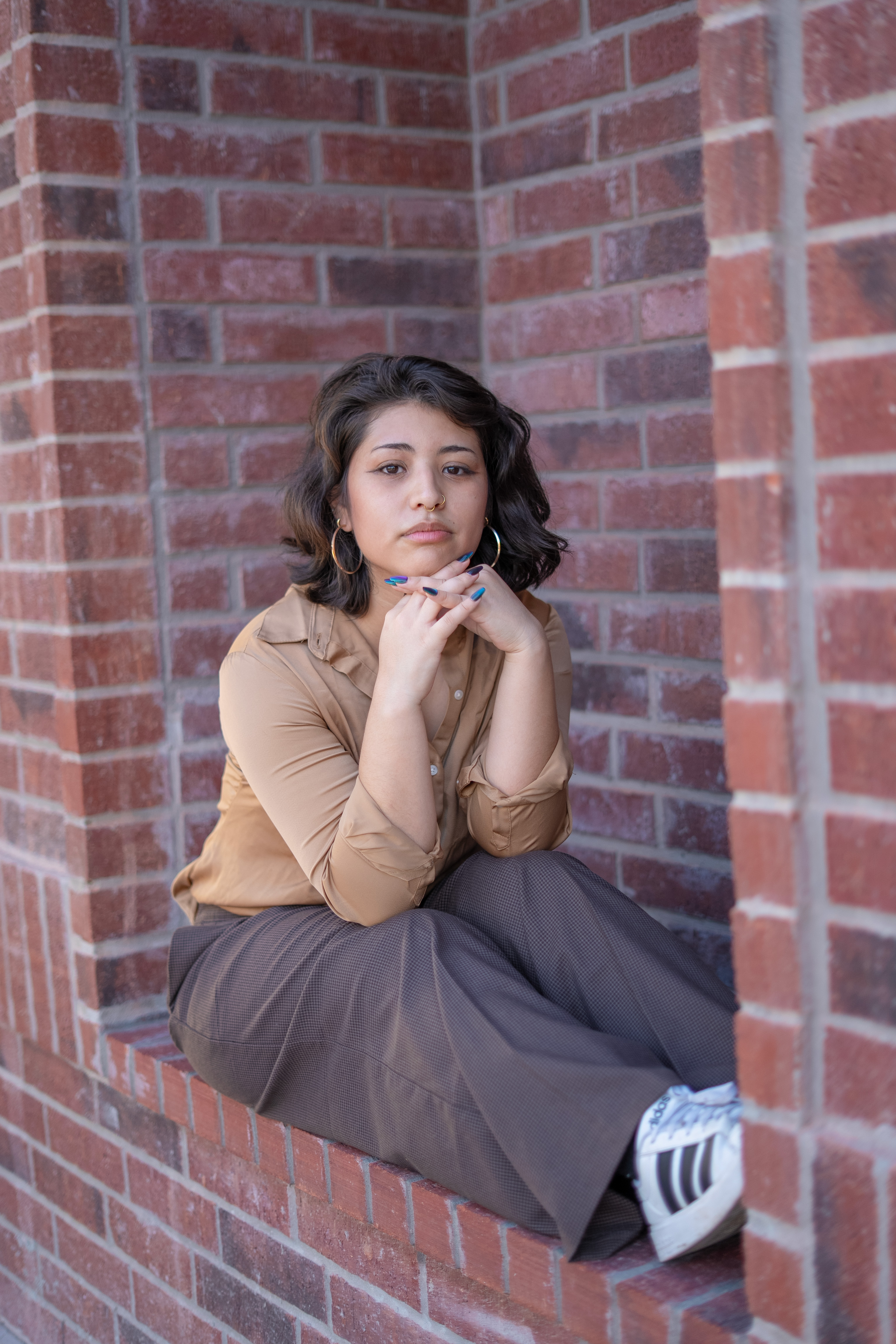 A young woman sitting on the floor holding two mini dachshunds.