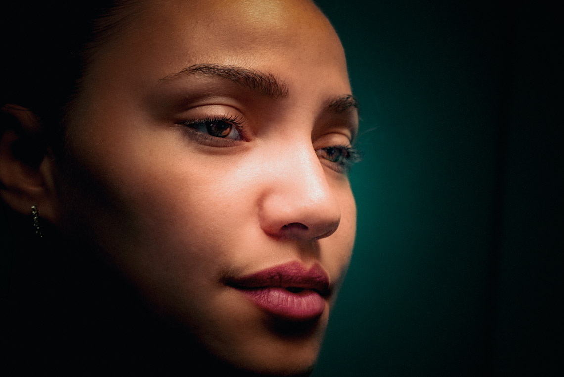 Dramatically lit close-up portrait.