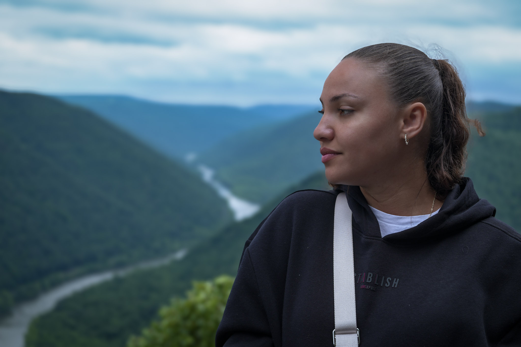 A woman framed by a mountain landscape.