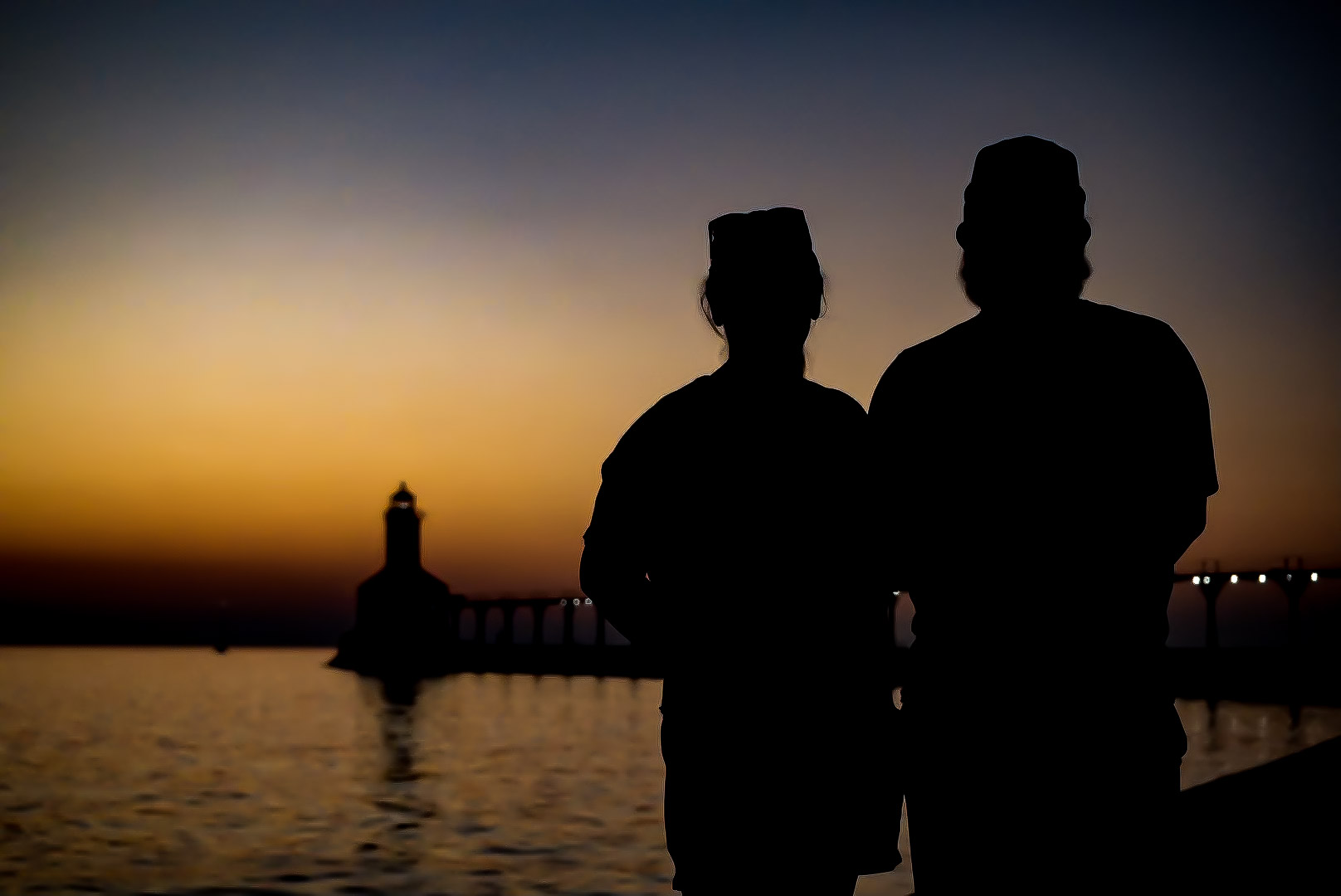 Two people silhouetted together against a golden sunset.