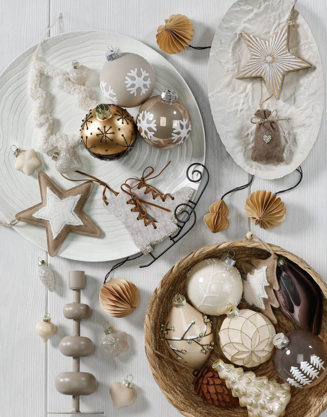 Weißer und goldfarbener Christbaumschmuck mit Sternen und Kugeln.
