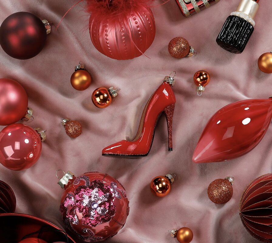 Rote und rosafarbene Weihnachtskugeln mit Glasornamenten in Lippen- und Schuhform.