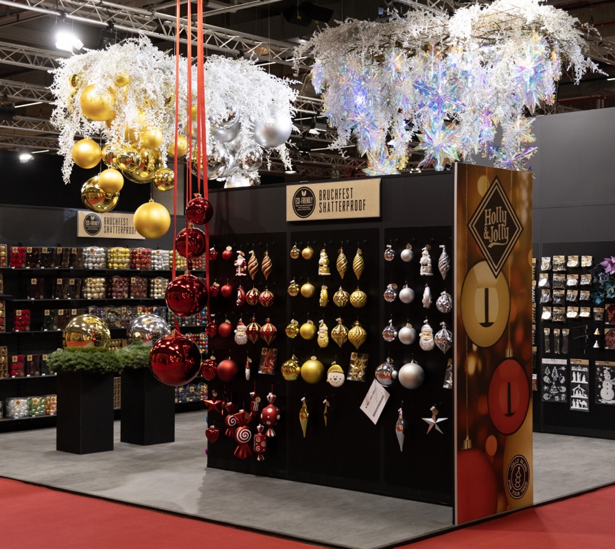 Präsentationswände mit farblich sortiertem Christbaumschmuck und hängenden Dekorationen.