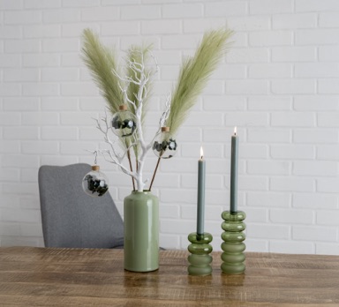 Grüne Vase mit Gräsern und grünen Kerzenhaltern
