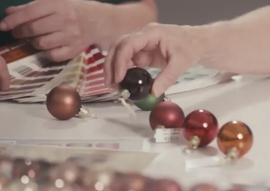 Farbfächer und kleine farbige Kugeln bei der Gestaltung eines Ornaments.