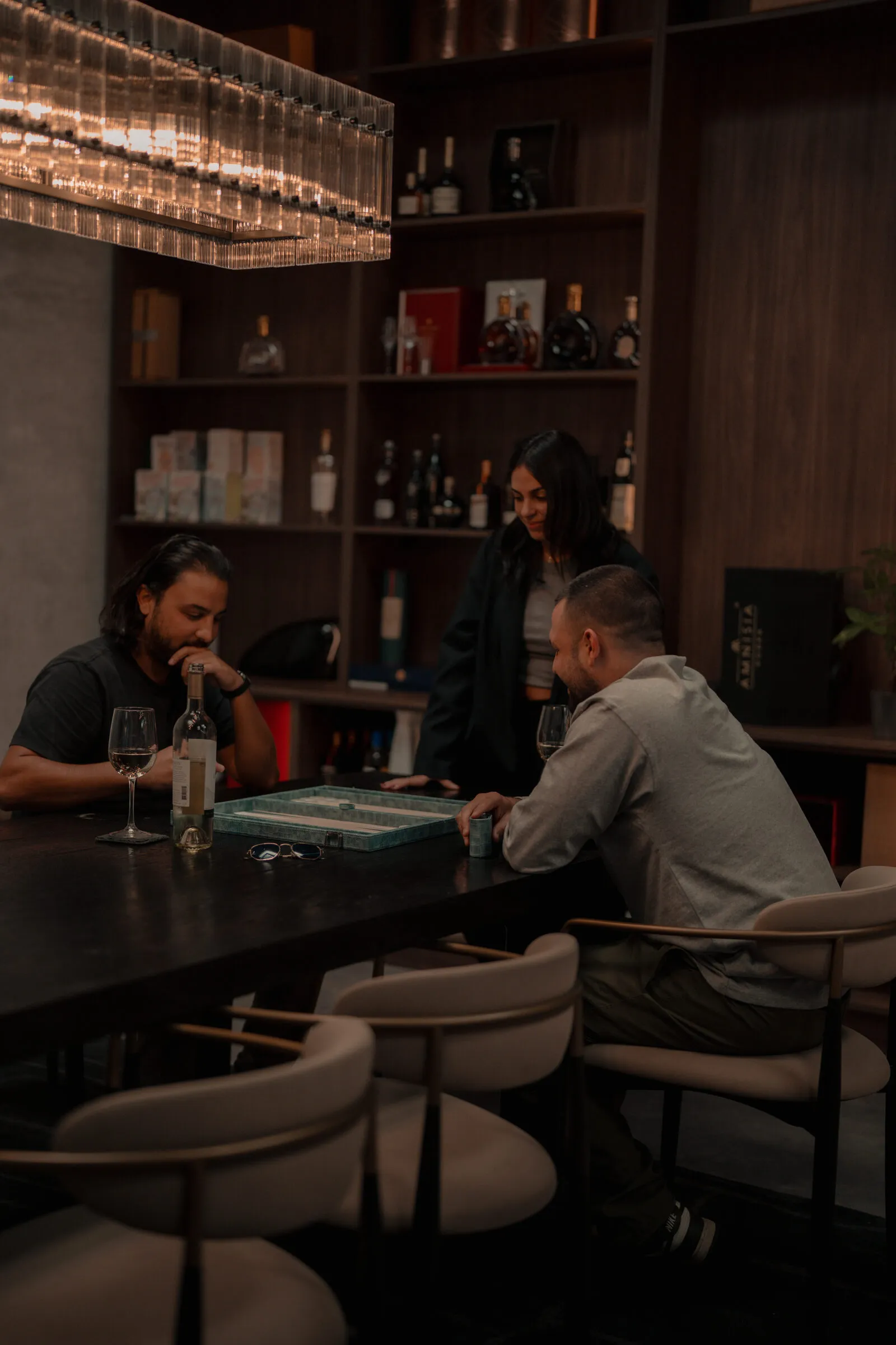 Players gathered around an MB Heritage backgammon board in a whisky bar.