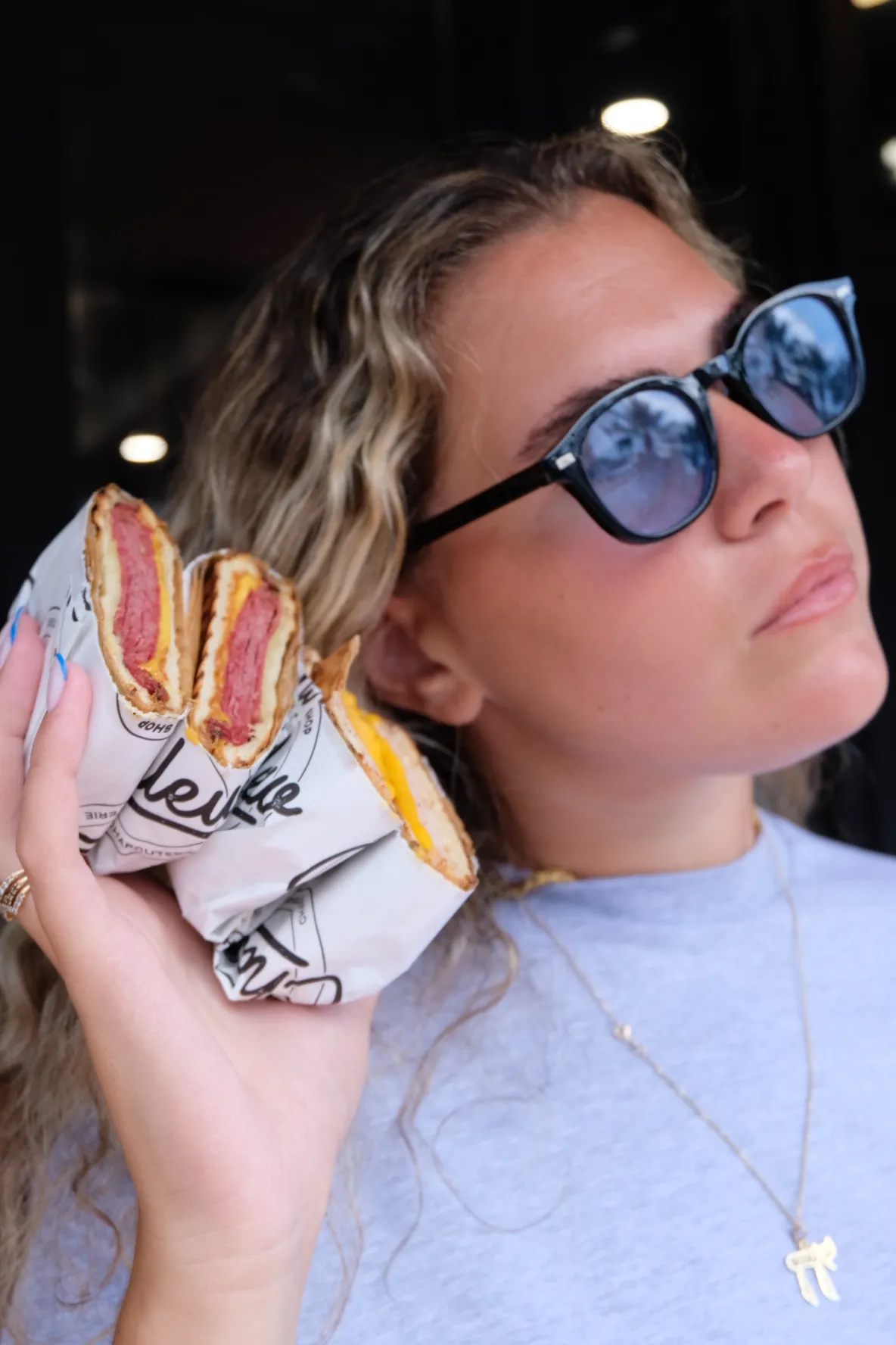 A guest biting into a Chlew Miami sandwich.