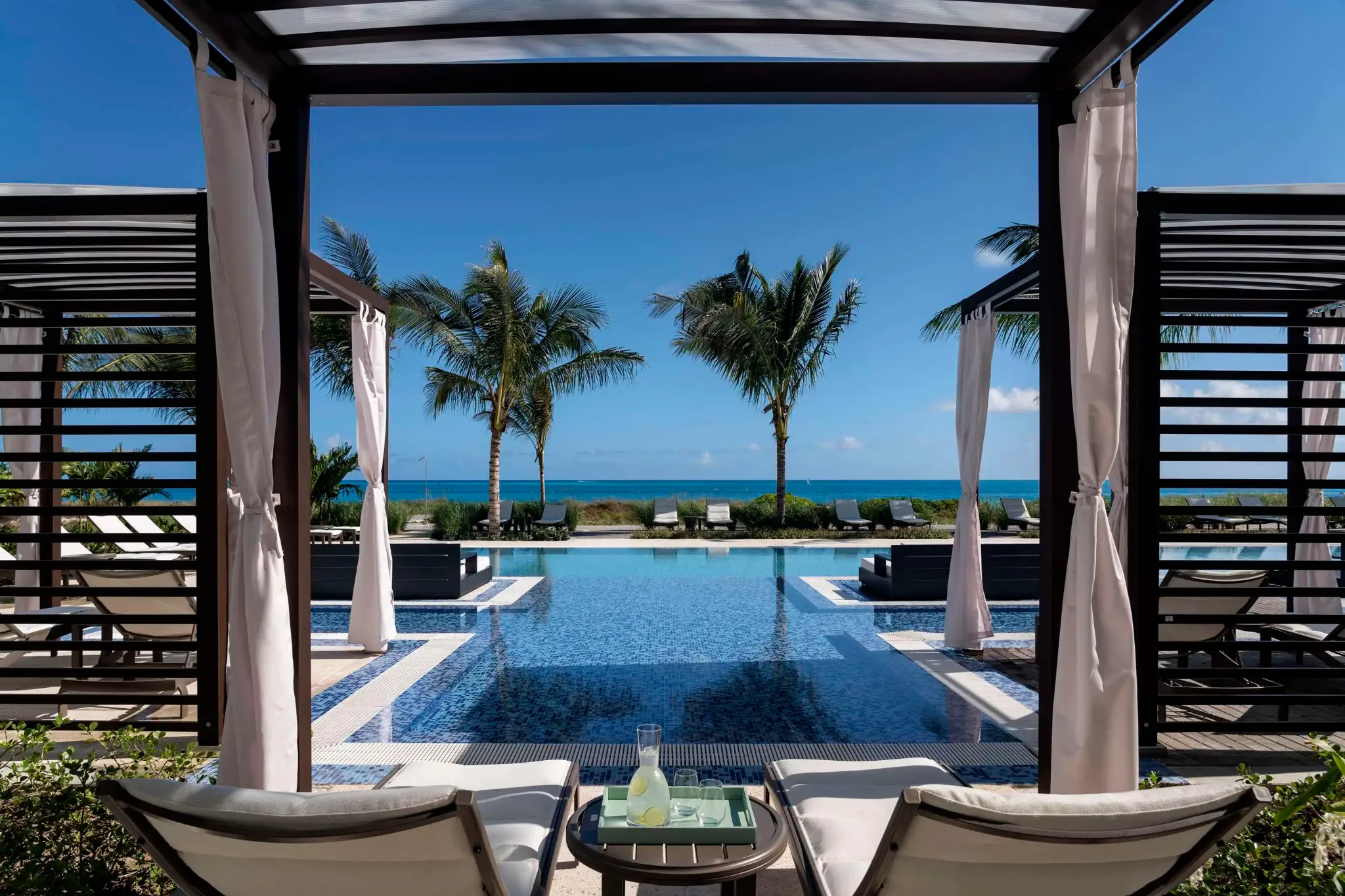 Beachfront pool and shaded cabanas overlooking Grace Bay at The Ritz-Carlton, Turks and Caicos