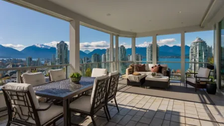 Condo balcony with patio furniture overlooking Vancouver's towers and North Shore mountains