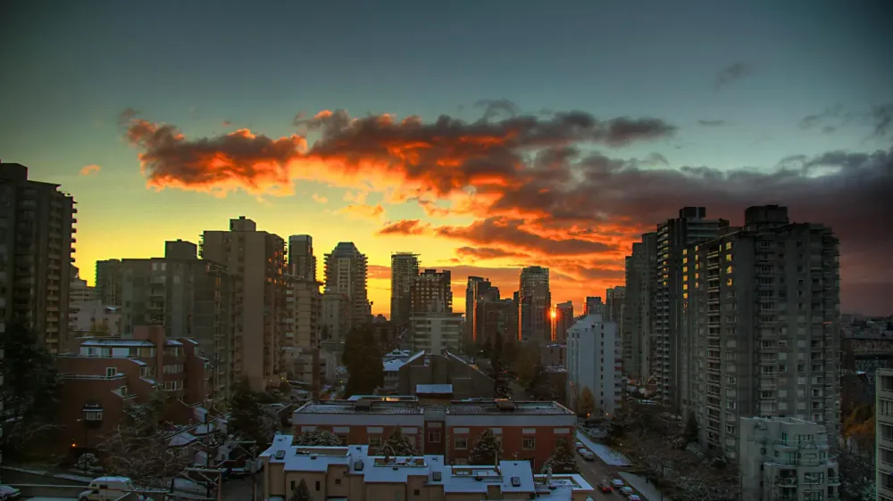 Downtown Vancouver high-rise skyline under an orange sunset sky