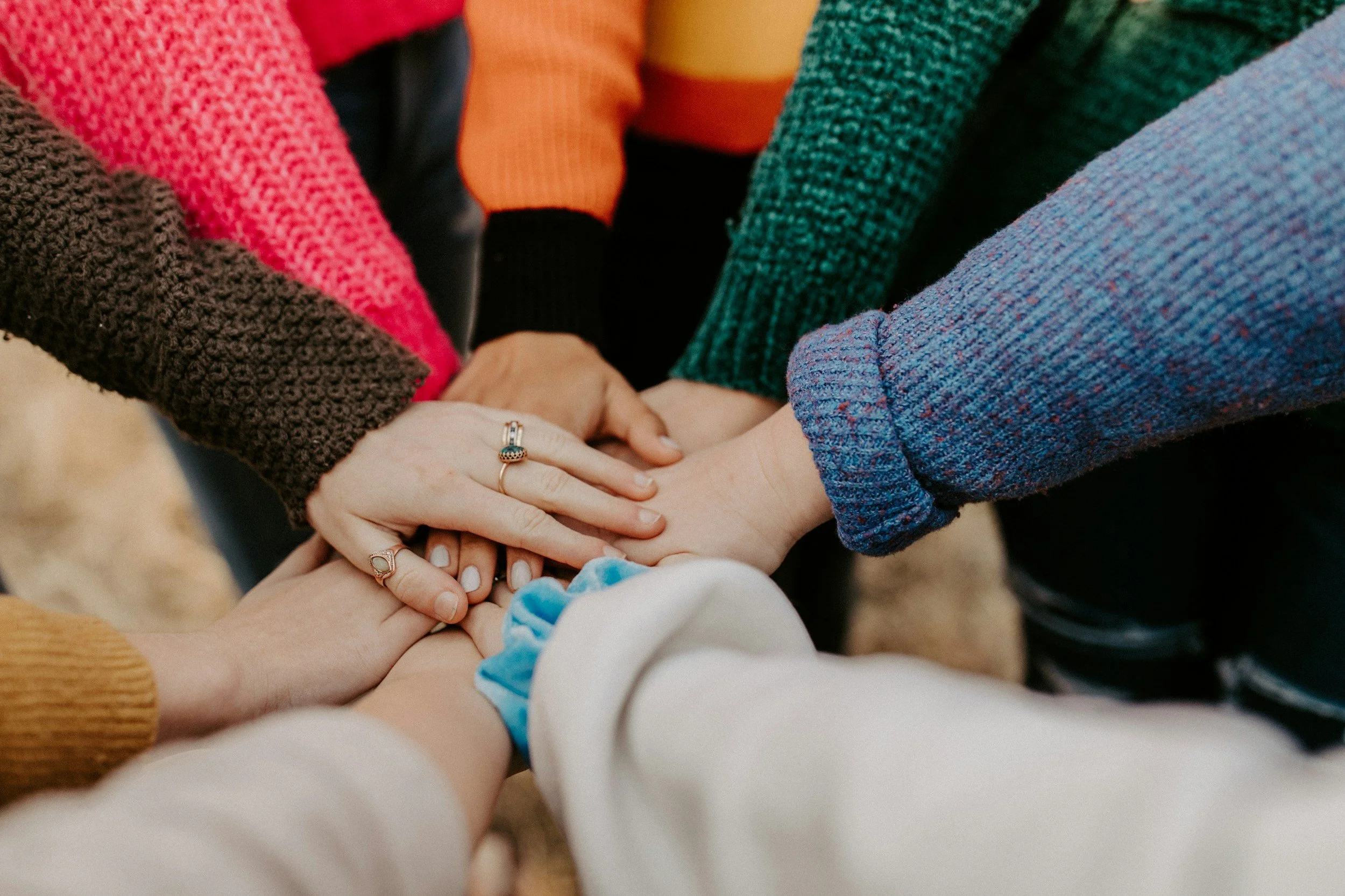 Community members stacking their hands together
