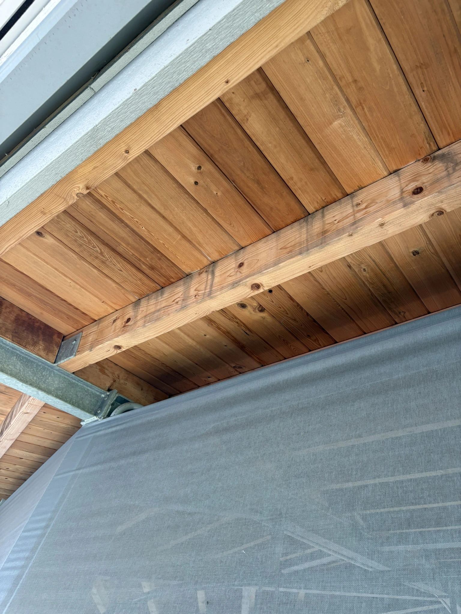 Weathered wood patio ceiling and exposed beams before restoration in Palm Beach County
