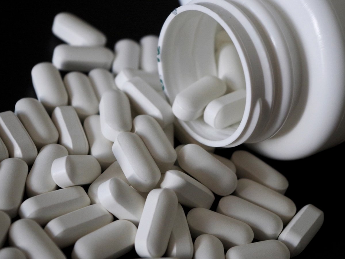 White supplement capsules spilling from a bottle