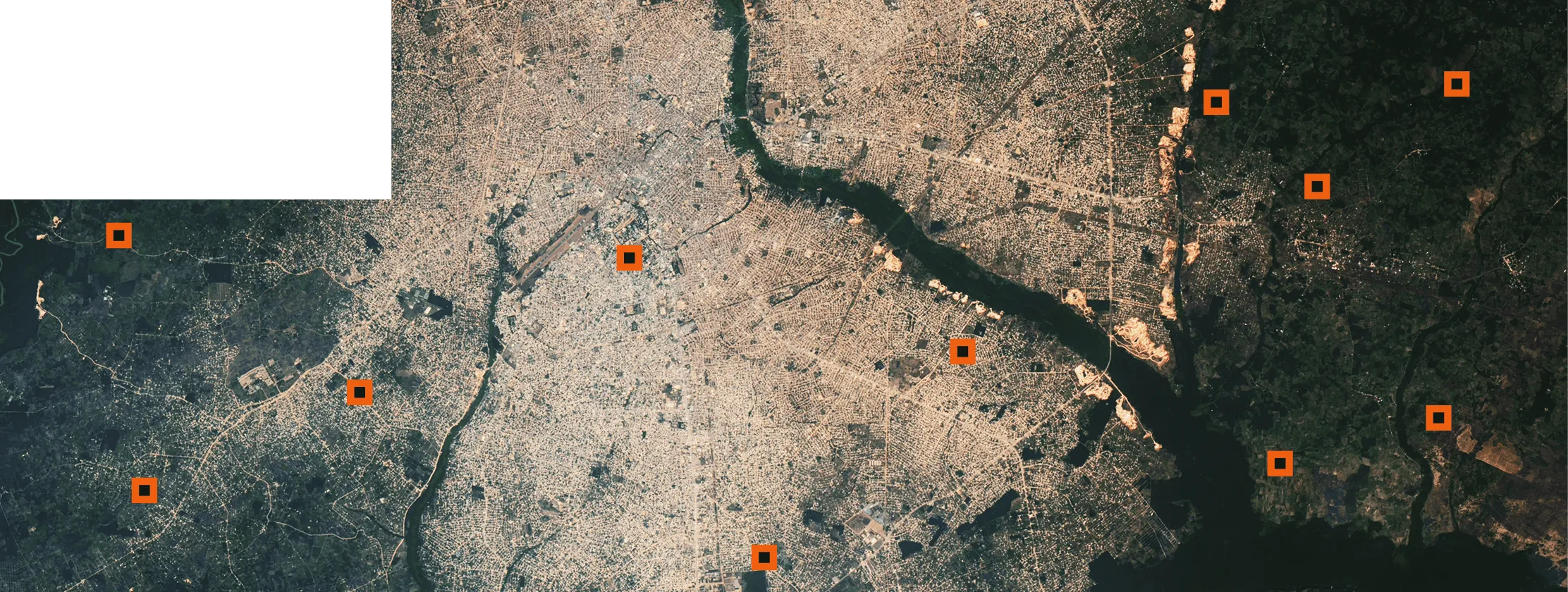 An aerial view of a dry landscape with a winding dark river or estuary cutting through the terrain, with scattered orange square markers overlaid on the map.