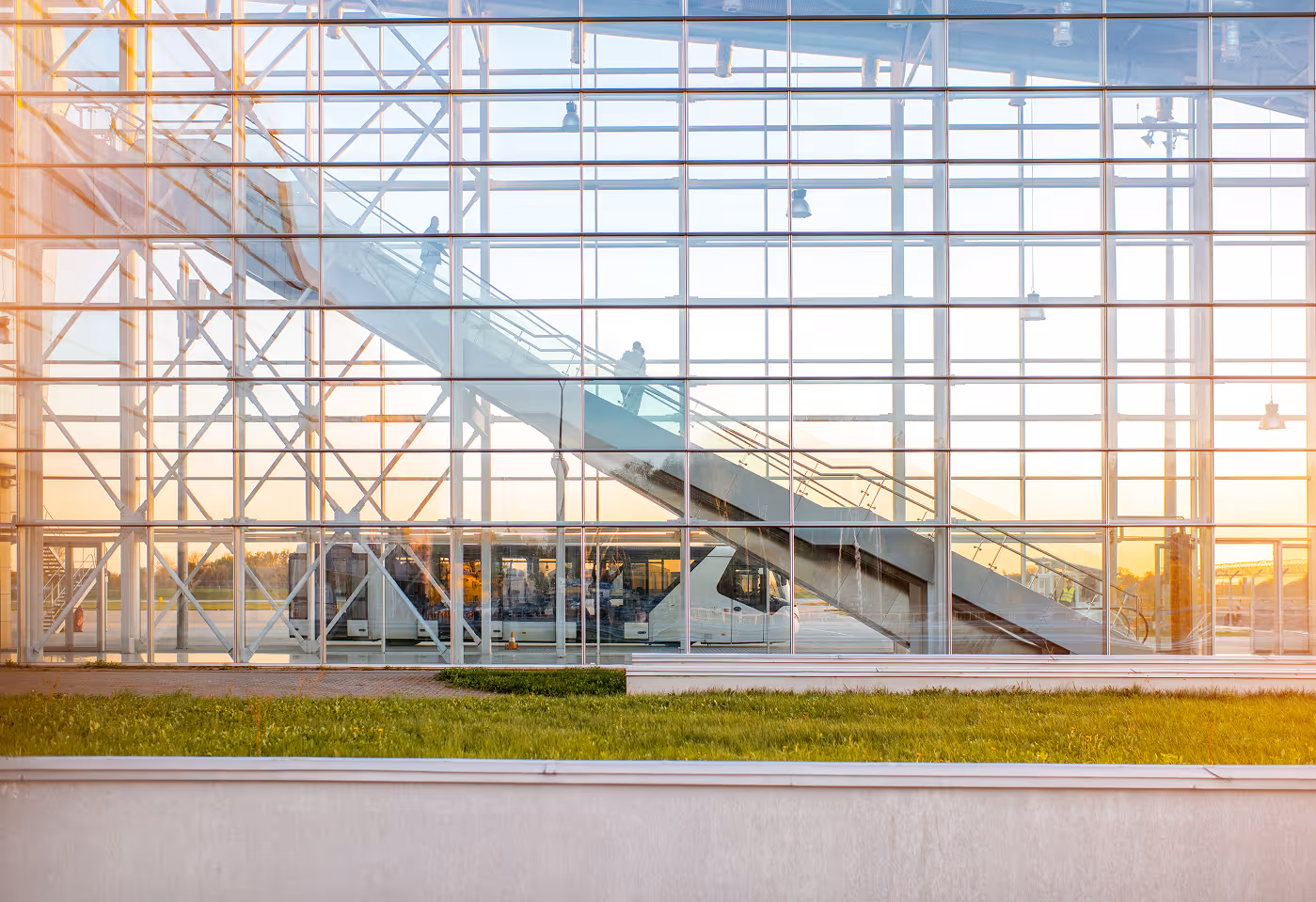 Modern airport exterior with escalator, representing seamless airline operations supported by Orbit