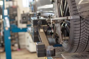 vehicle in repair shop up on lift with equipment in background