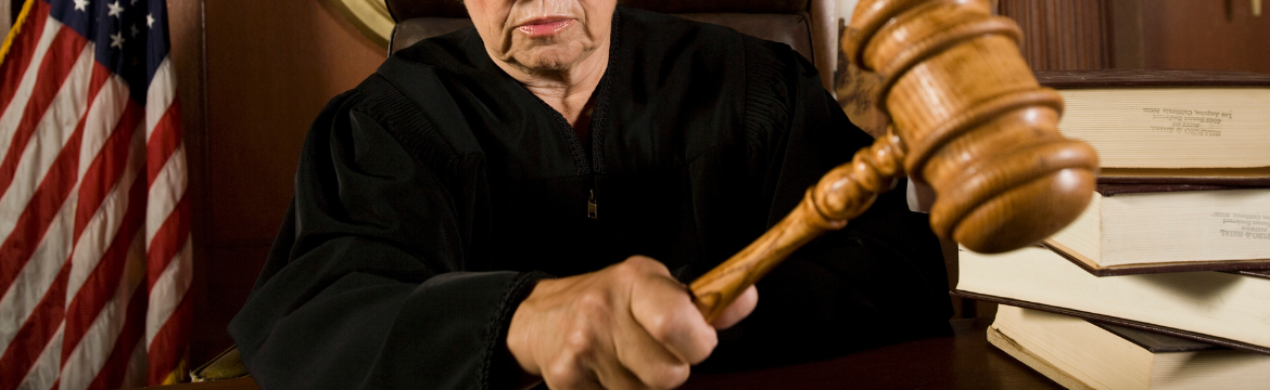 Partial Image of female judge knocking her gavel which is representative of nuclear verdicts and the liability crisis in insurance. Simpson McCrady.