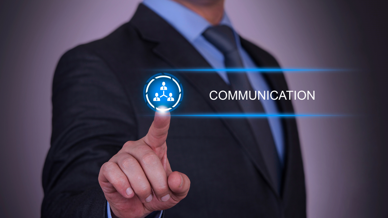 Businessman in suit pressing a glowing icon with network figures and the word COMMUNICATION.