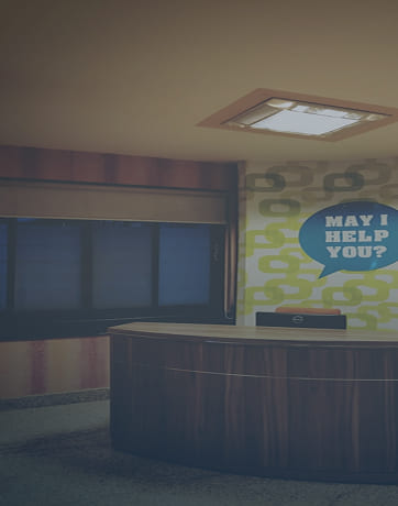 Hotel front desk with 'May I help you?' speech bubble on wall behind it.