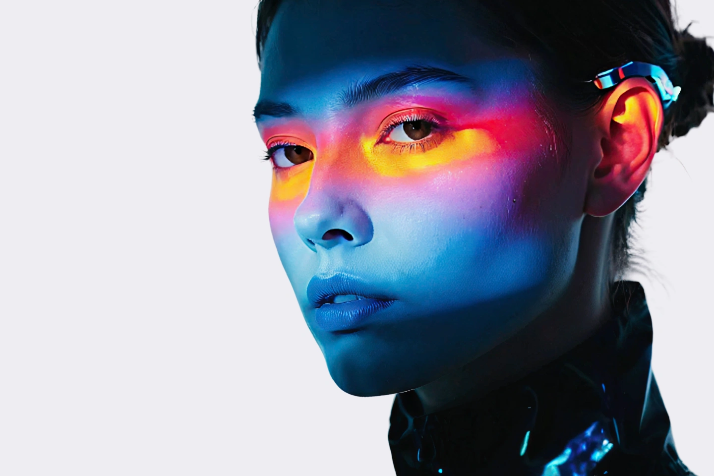 Close-up of a woman’s face with blue lighting and neon red-yellow light across her eyes and cheeks.
