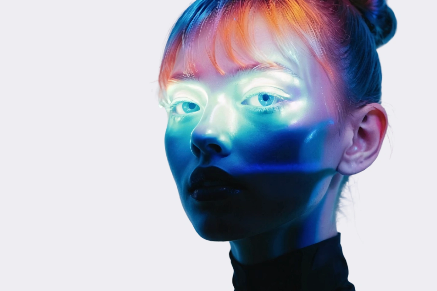 Close-up of a person’s face with colorful neon lighting in blue, purple, and orange hues.