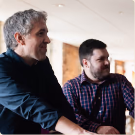 Two Encore team members in conversation during a meeting.