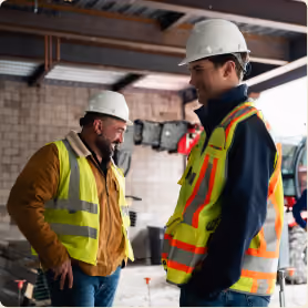 Two Encore construction team members talking on site.