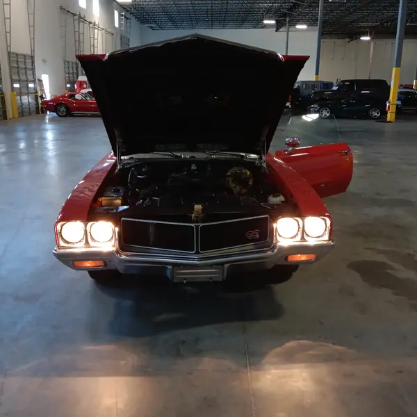 Red Buick GS muscle car with headlights on during a classic muscle car appraisal