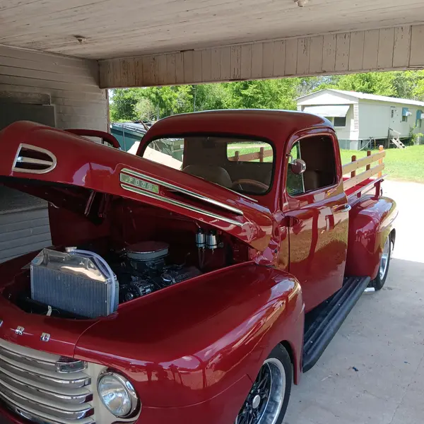 Candy red Ford F1 pickup restomod with hood open during a custom truck appraisal