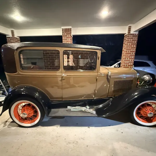 Restored tan Ford Model A Tudor sedan with orange wire wheels after an appraisal