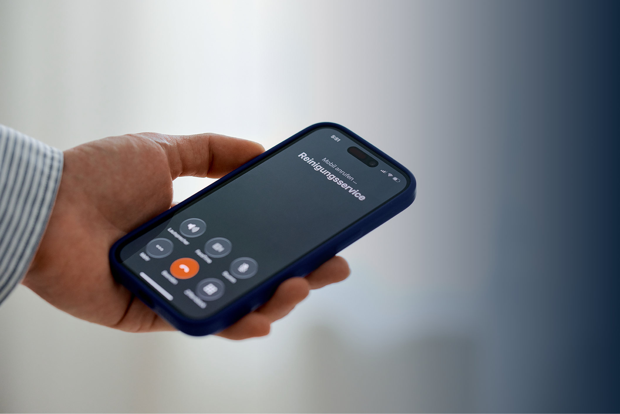 Hand hält ein Smartphone mit einem Anruf beim Reinigungsservice auf dem Bildschirm.