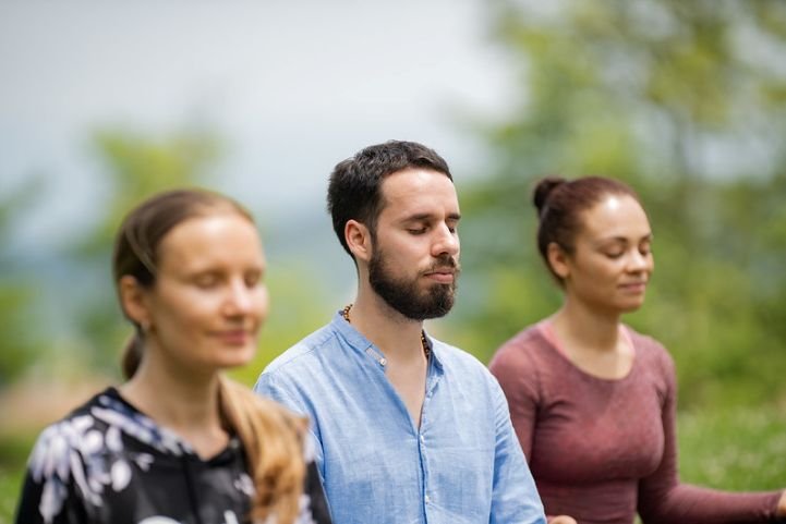 Two women and a man practicing SKY Breath Meditation for emotional resilience.