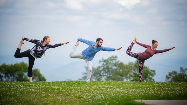 Three people performing yoga for physical recovery from panic attacks.