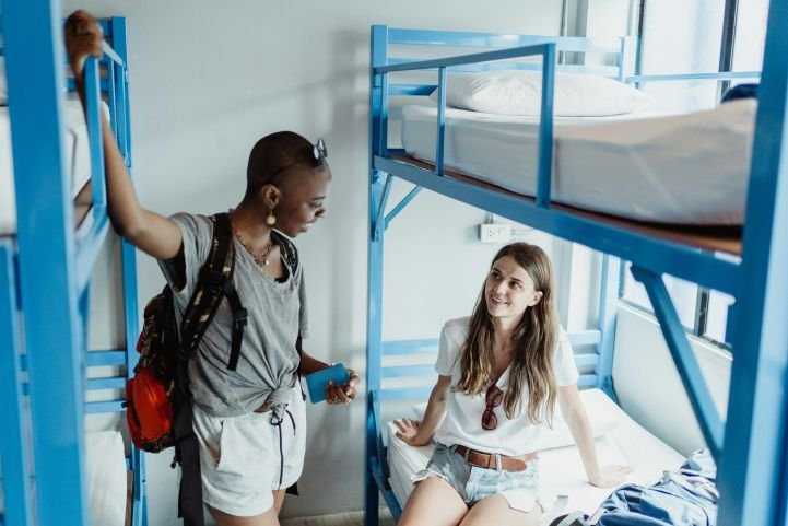 Two young women are making connections in a youth hostel.